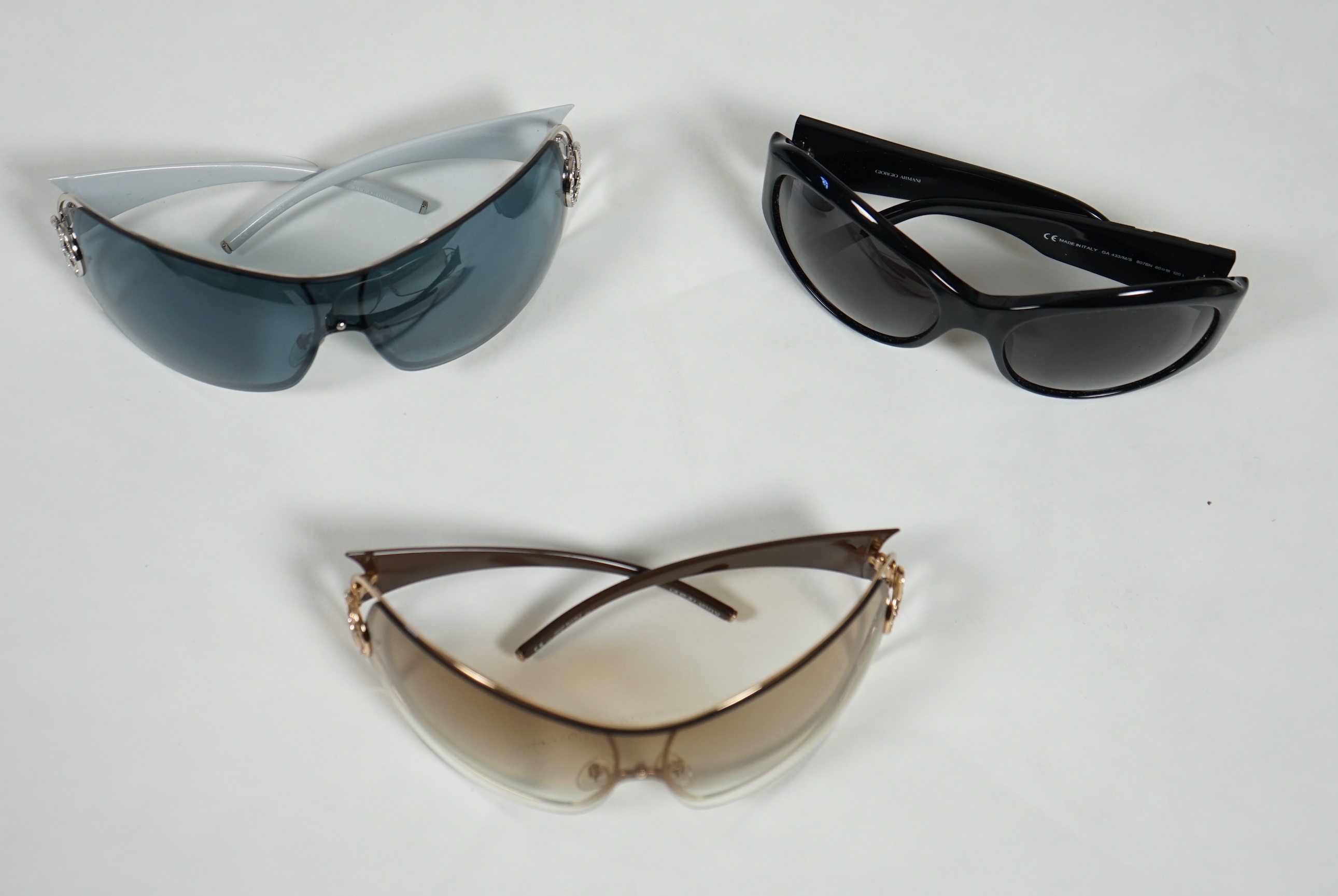 Three pairs of lady's Giorgio Armani sunglasses with cases and dust bags.